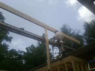 Carpenter setting a ridge beam over a new addition frame — Ice Dam Removal by Roofing Brothers in Kaufman