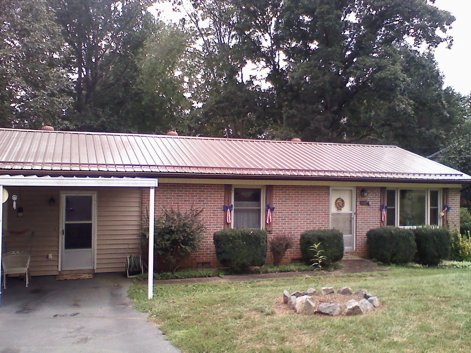 Bronze metal roof and carport on a brick ranch home — Roof Repair work by our crew in Kaufman