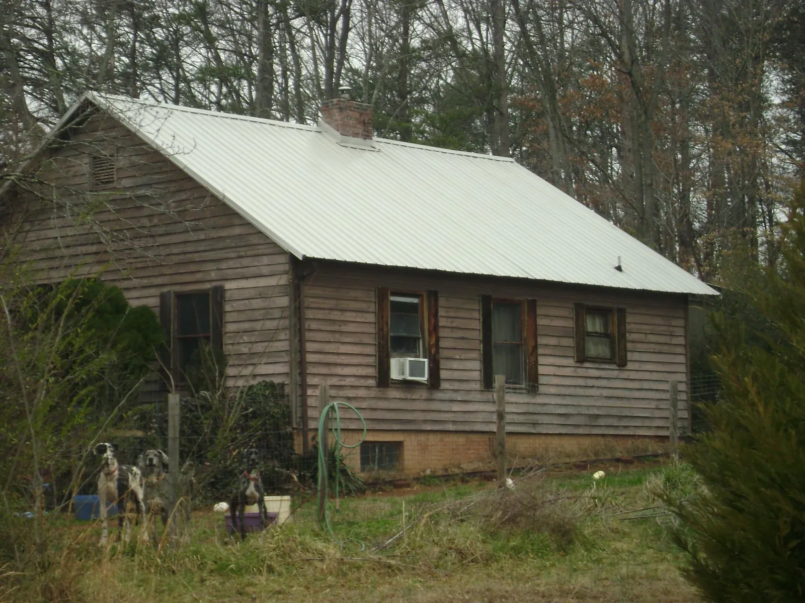 White metal roof on an old wood sided farmhouse, from a Asphalt Shingle Roof Repair job in Kaufman